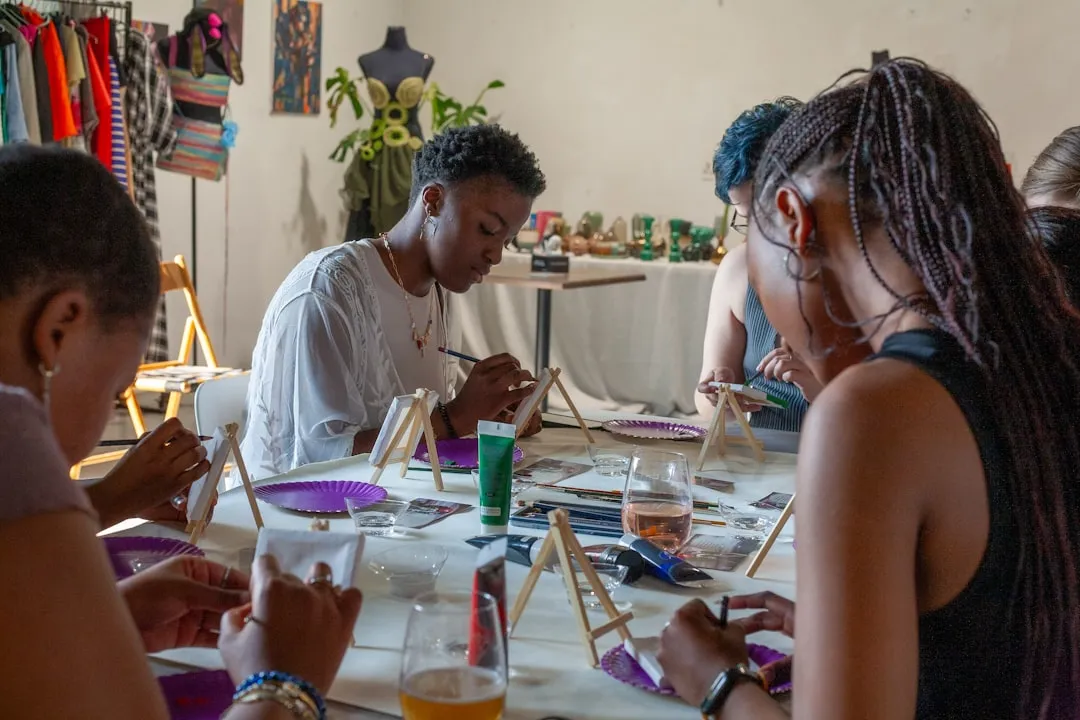People painting at a table in an art class.